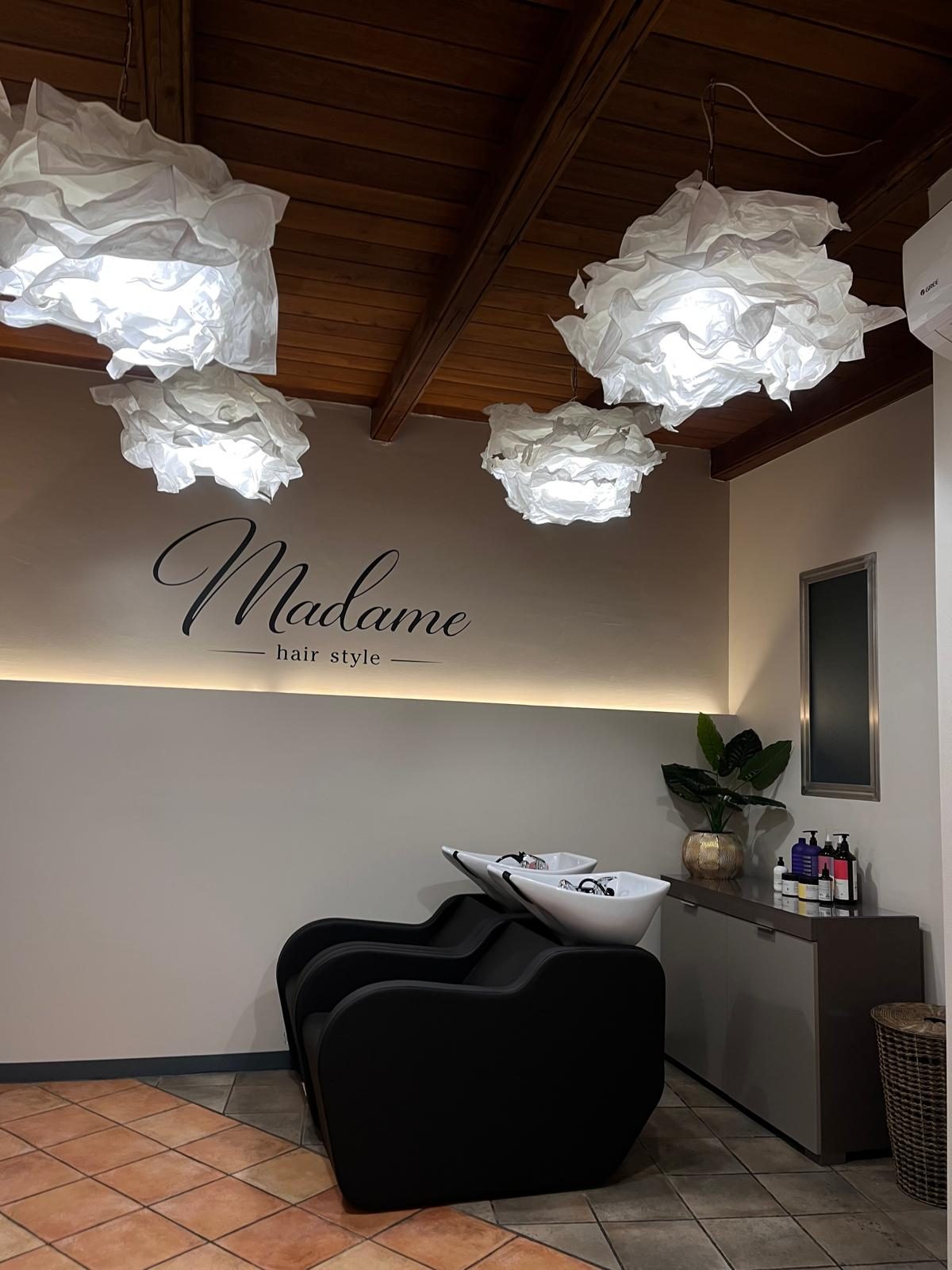 La zona lavaggio con le lampade di carta e il logo Madame hair style